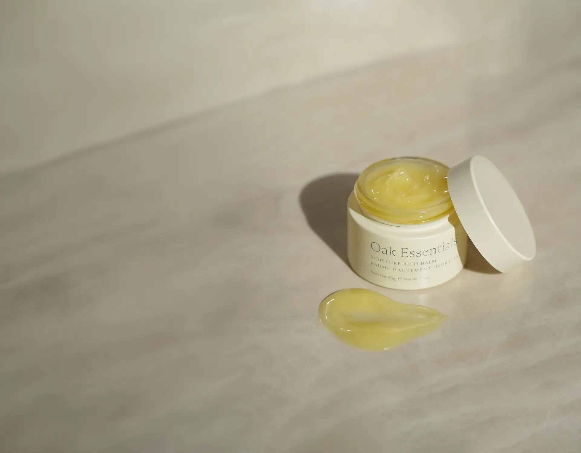 Oak Essentials Moisture Rich Balm jar with a swatch of golden balm