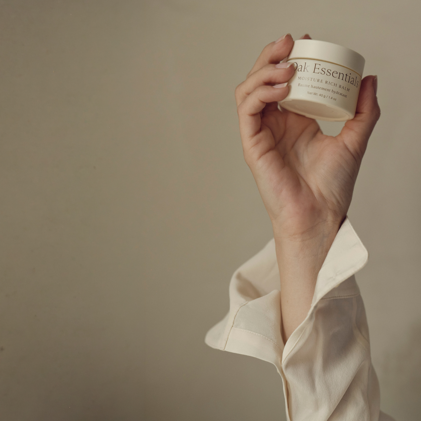 Hand holding the Moisture Rich Balm jar